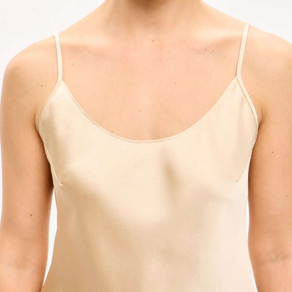 
                  
                    Sleeveless, light-colored slip dress.
                  
                