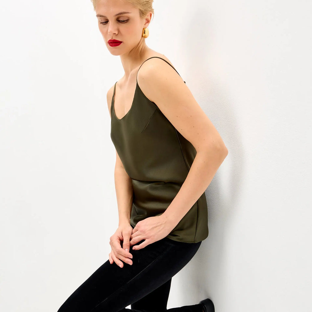 
                  
                    Woman in olive green camisole and black velvet pants.
                  
                