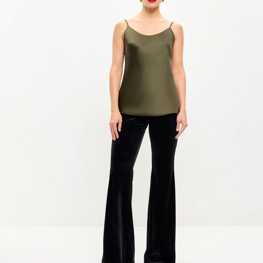 Woman in olive green tank top and black velvet bell-bottom pants.